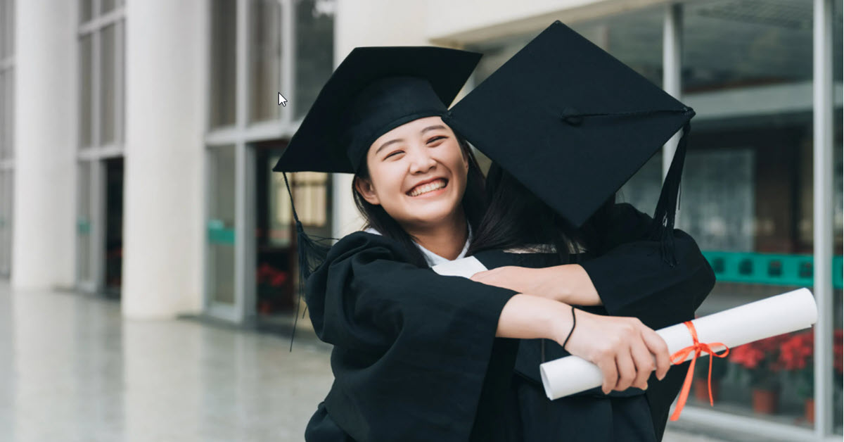 Two graduates embracing