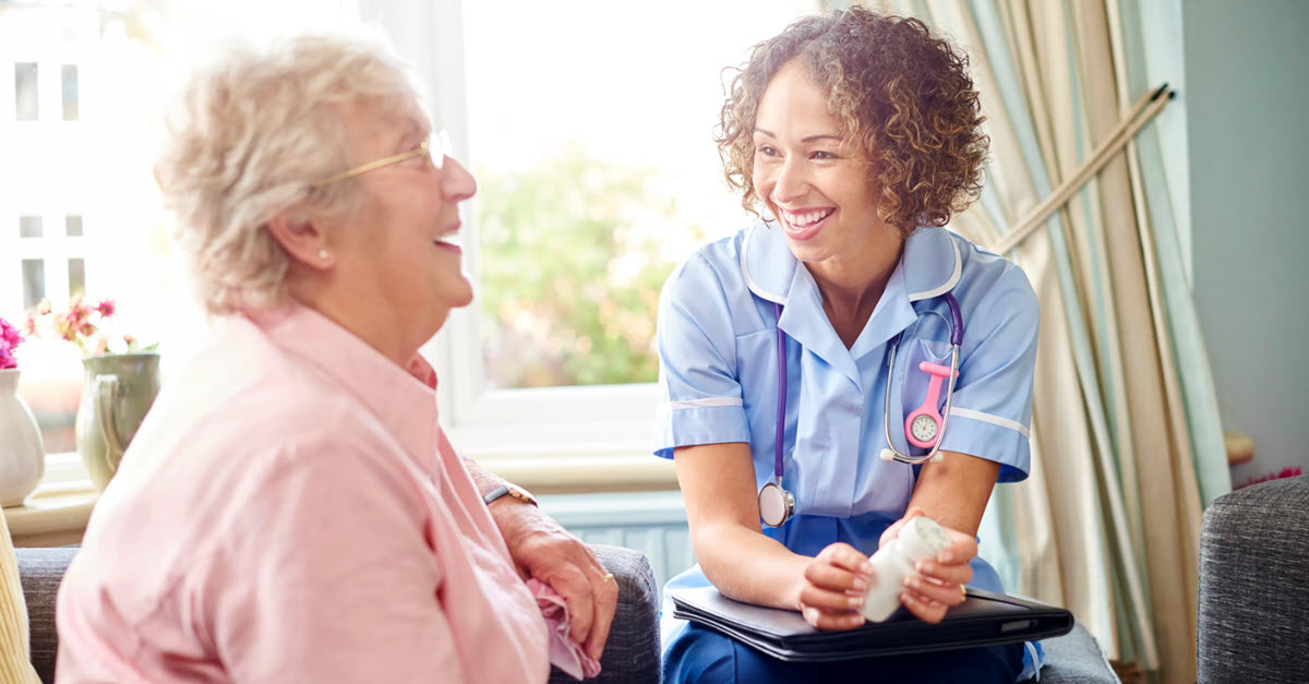 Elderly woman laughing with nurse