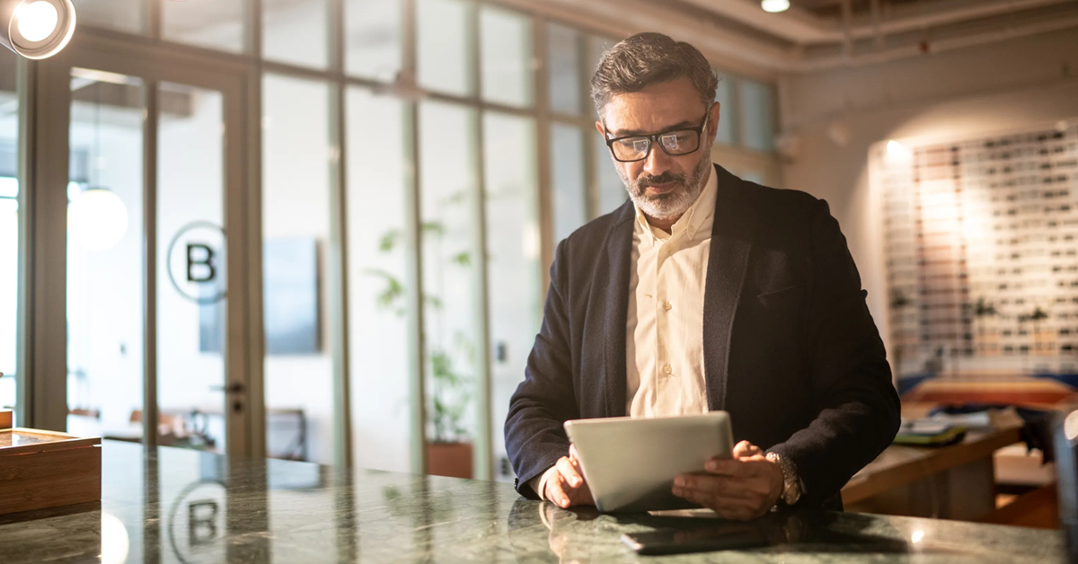 mature business owner looking at ipad