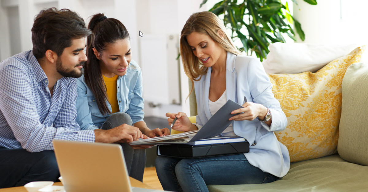 Financial advisor reviewing life insurance options with a young couple.