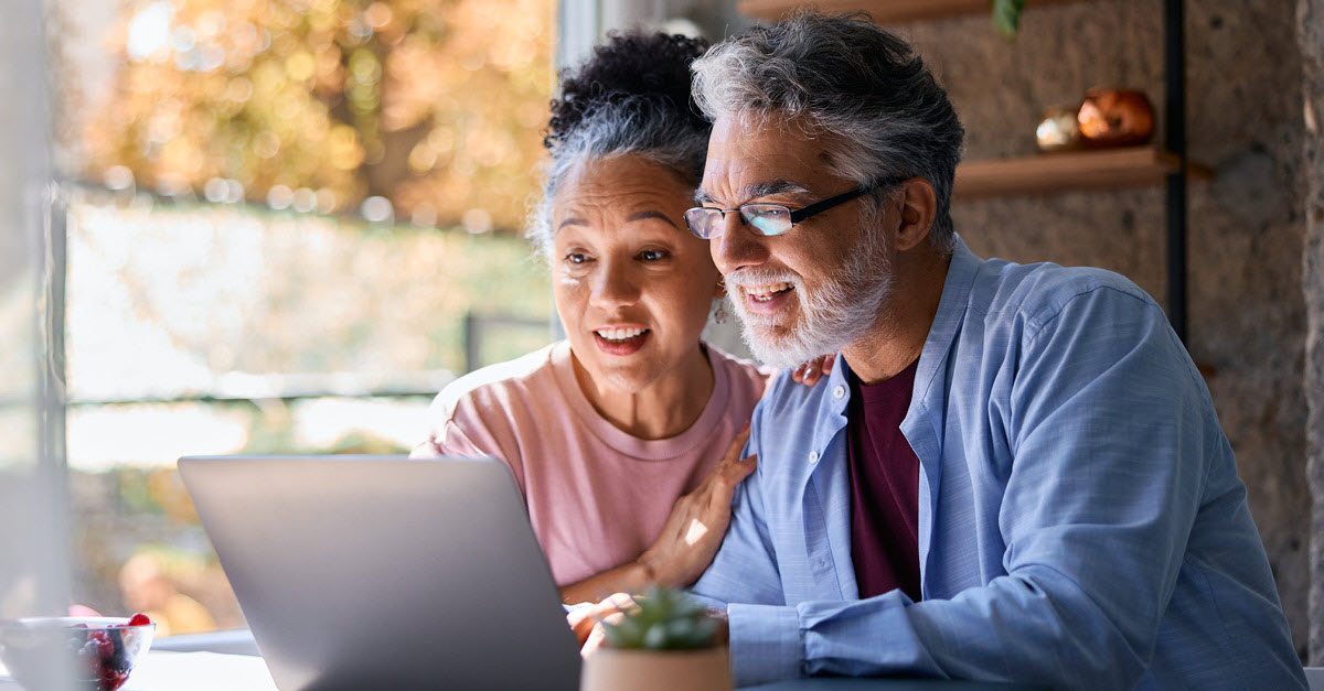 Mature couple looking at a computer discussing taxes