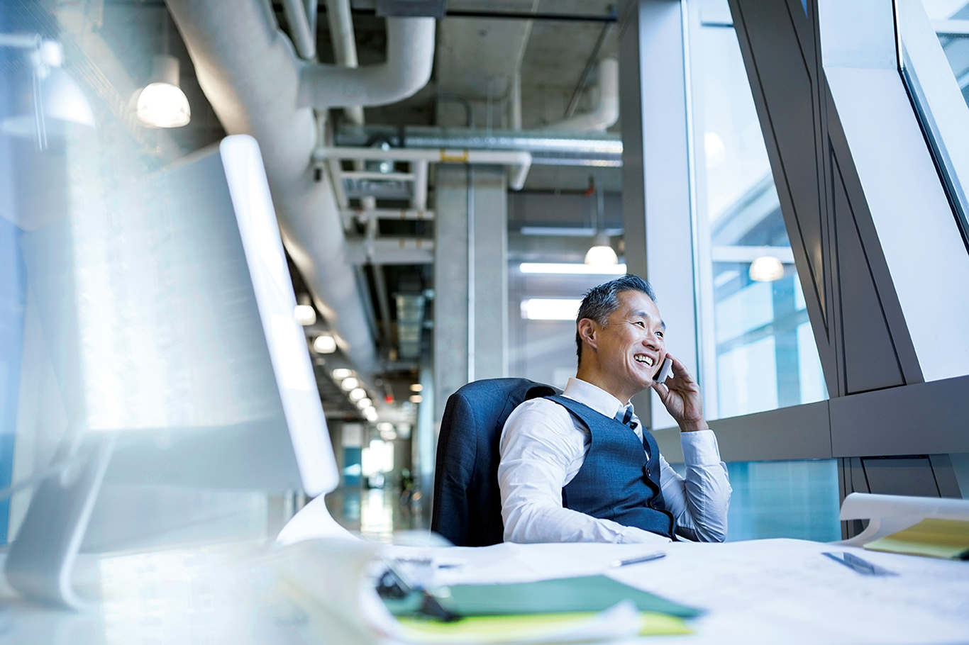 Business Owner sitting at desk looking out window in office